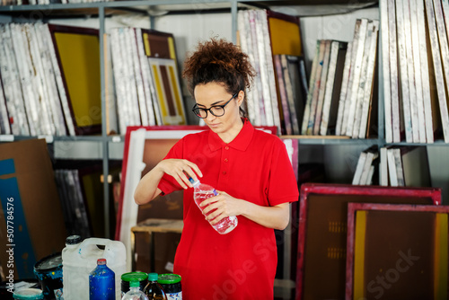 A printing shop worker using paint thinner in facility. photo