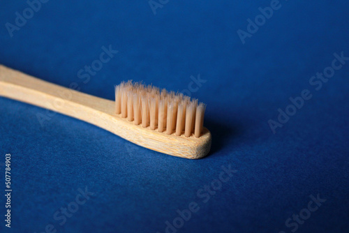 Natural bamboo toothbrush isolated on blue background. Copy space. Eco friendly  zero waste. 