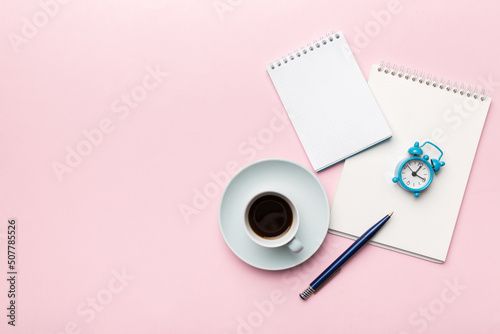 Modern office desk table with notebook and other supplies with cup of coffee. Blank notebook page for you design. Top view, flat lay