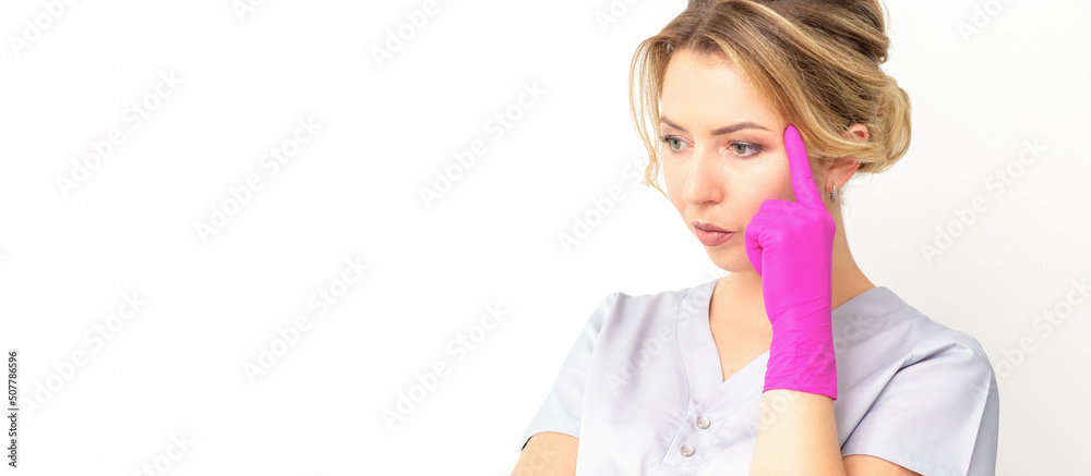 Young caucasian female doctor wearing gloves thoughtful looking away isolated on white background Young caucasian female doctor wearing gloves thoughtful looking away isolated on white background