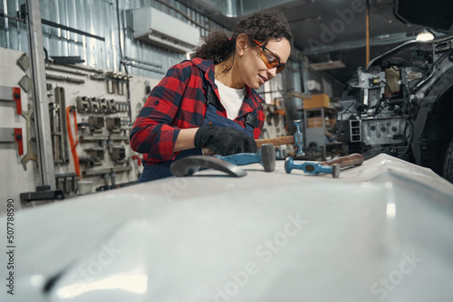 Woman auto mechanic working in automobile garage