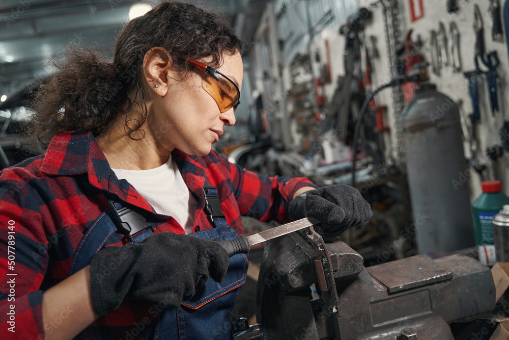 Female auto mechanic working in car repair garage