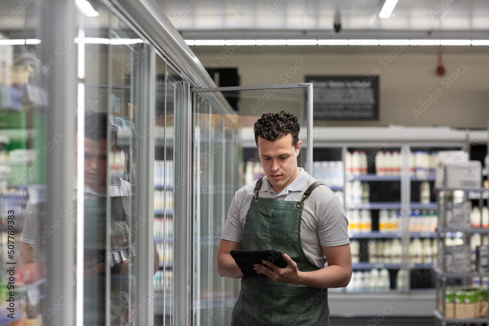 Employee of a food market stock taking with a digital tablet Employee of a food market stock taking with a digital tablet