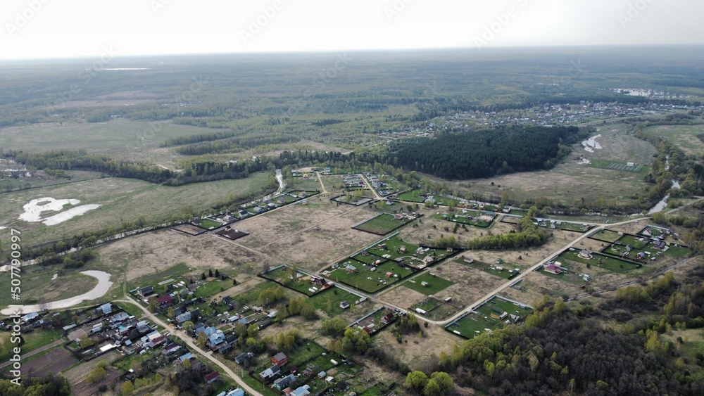 view from the height of the village with streets, plowed fields, meadows in summer. Rural landscape from a height shooting on a quadcopter, green areas view from the height of the village with streets, plowed fields, meadows in summer. Rural landscape from a height shooting on a quadcopter, green areas