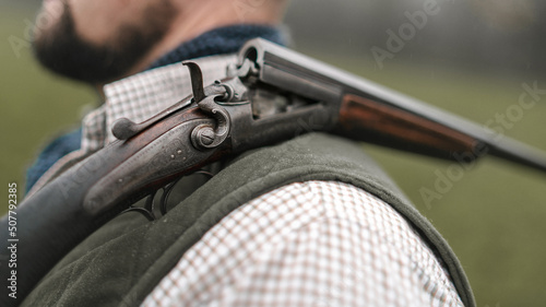 Fotografie Close-up of unter man in traditional shooting clothes with shotgun on his shoulder