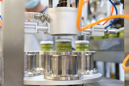 close up on Pesto sauce Industrial process. vacuum sealing machine for canned food. production of Pesto sauce. Vacuum Seamer for Cylindrical Cans of Rotary Type. photo