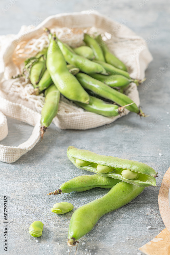 Fresh and raw green broad beans on kitchen table. Fresh and raw green broad beans on kitchen table.