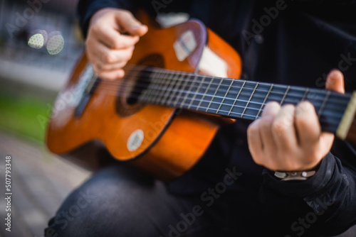 Street musician. A man plays the guitar on a city street.