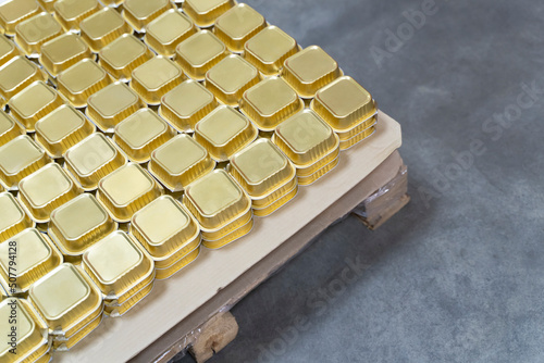 Aluminium Foil Food container. light packaging of canned food, sweets and desserts, ready-made takeaway food. Canned food, pate packaged container stand on a pallet in production hall