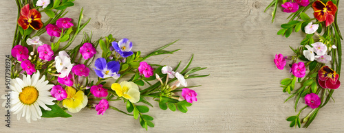 Flower arrangement of daisies  phloxes and violets on gray background. Wide photo.