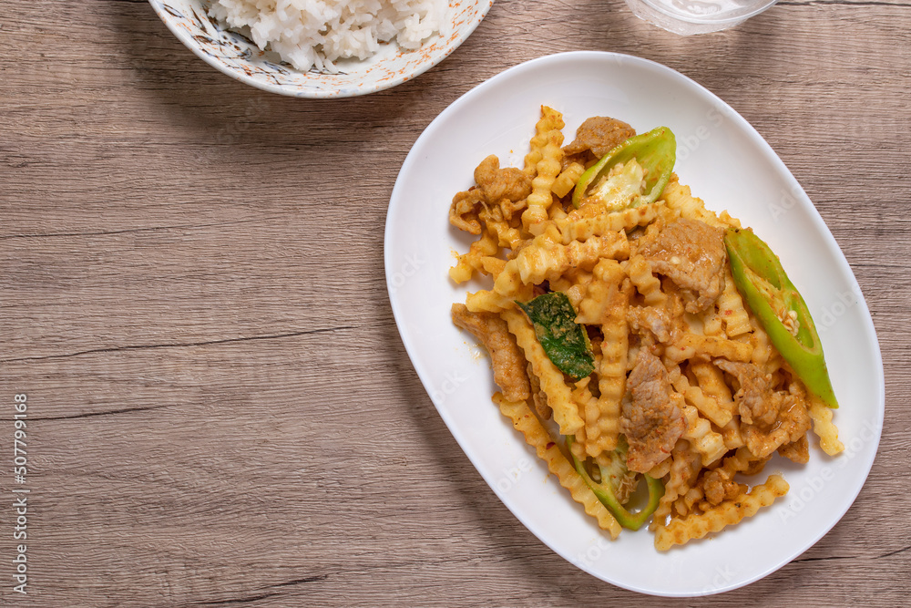 Stir-fried pork with red curry paste and young coconut shoots in a white plate Stir-fried pork with red curry paste and young coconut shoots in a white plate