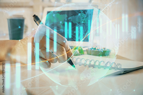 Financial forex graph drawn over hands taking notes background. Concept of research. Multi exposure