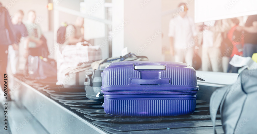 Fototapeta premium Concept banner baggage luggage on tape claim at airport, sunlight