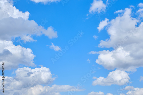 Background cumulus clouds against a blue sky illuminated by sunlight. © freeman83