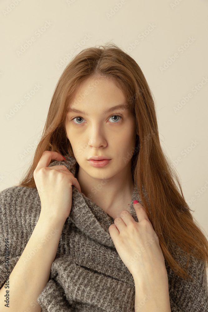 Portrait of young red-haired girl in sweater posing isolated over grey studio background. Natural beauty Portrait of young red-haired girl in sweater posing isolated over grey studio background. Natural beauty