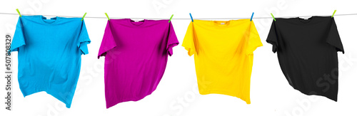 Colorful CMYK colored t-shirts on clothes line isolated white background. Cyan magenta yellow key symbol and printing indursty concept.