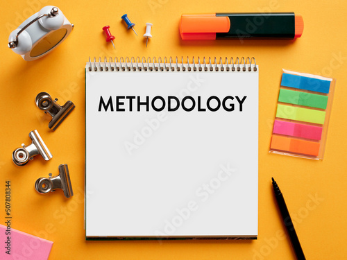 The word methodology written on a notebook on business office desktop. photo