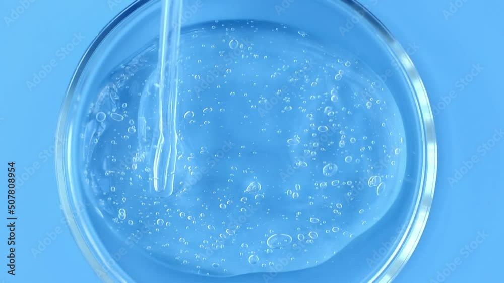 serum gel texture in petri dish on blue background close up serum gel texture in petri dish on blue background close up