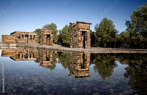 panorama of the Debod temple reflected in a water pond with blue sky in the city of Madid Spain