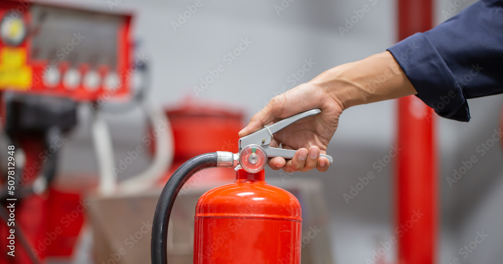 Engineer are checking and inspection a fire extinguishers tank in the fire control room for safety training and fire prevention. Engineer are checking and inspection a fire extinguishers tank in the fire control room for safety training and fire prevention.