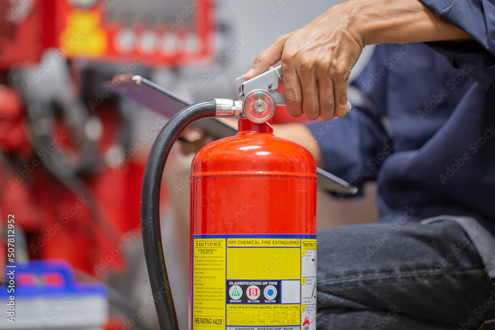 Engineer are checking and inspection a fire extinguishers tank in the fire control room for safety training and fire prevention.