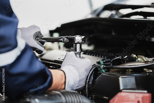 Professional mechanic working on the engine of the car in the garage. Car repair service.