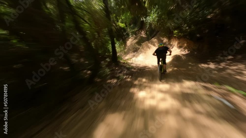Mountain-bike rider riding fast at forest Trail Pathan followed by fpv drone  photo