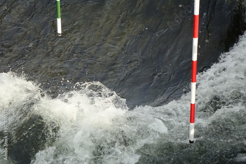 Canoe (whitewater) slalom course with red-white and green-white gates in spring, concept: adrenaline, refreshment, challenge (horizontal), Hildesheim, Lower Saxony, Germany