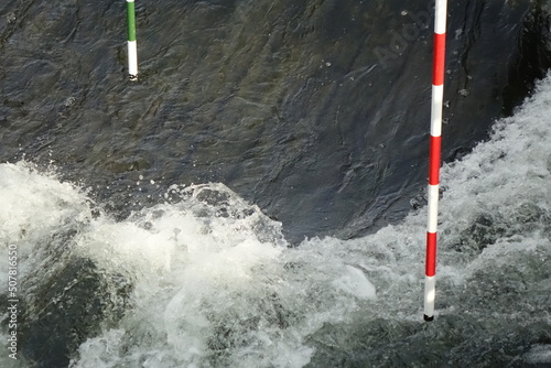 Canoe (whitewater) slalom course with red-white and green-white gates in spring, concept: adrenaline, refreshment, challenge (horizontal), Hildesheim, Lower Saxony, Germany photo