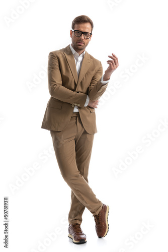 businessman holding his elbow with elegance, crossing his feet