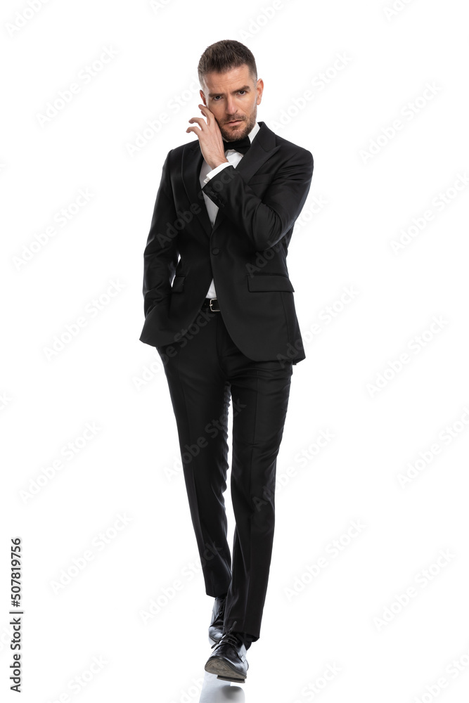 businessman walking towards the camera while touching his face businessman walking towards the camera while touching his face
