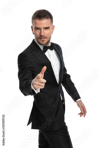 businessman gesturing a fingergun and pointing at the camera