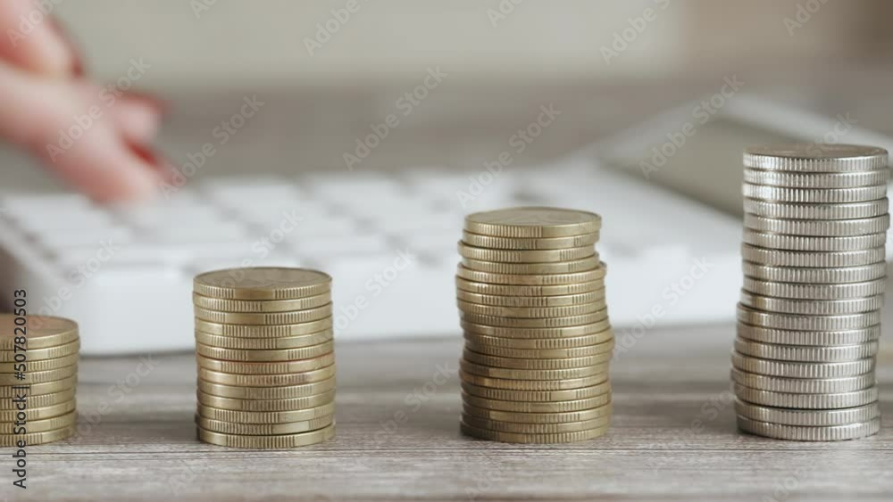 A woman is calculating her expenses for a month. Coins for taxes or payments. Concept of poverty savings money or counting budget and unemployment. Close up A woman is calculating her expenses for a month. Coins for taxes or payments. Concept of poverty savings money or counting budget and unemployment. Close up