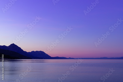 Inspiring and calming dawn at sea  beautiful blue  pink and purple colors. Sky calmness tranquil relaxing sunlight summer mood. Vacation travel holiday background.