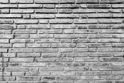 Old black and white brick wall background texture close up.