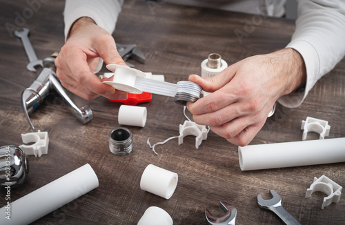 Tableau sur toile Plumber putting a teflon tape. Repair of water pipes