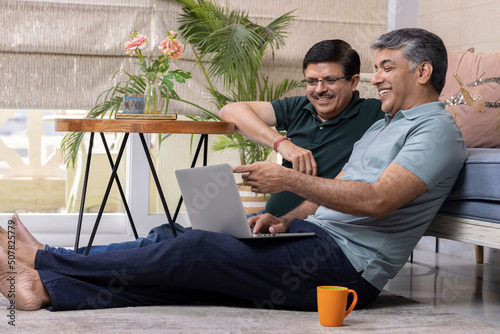 Photography Two businessmen having coffee while discussing work at home