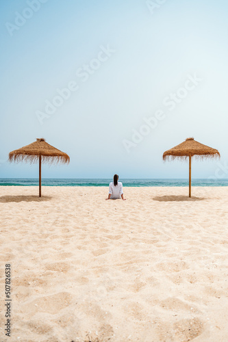 Female traveler sitting on sand near ocean © DavidPrado