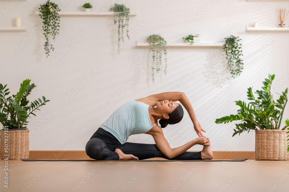 © 220 Selfmade studio - Calm of Asian woman in sportwear stretching muslce to warm up breathing and meditation with yoga at home.Healthy female doing yoga Feeling so comfortable and relax,Wellness Yoga Healthcare Concept