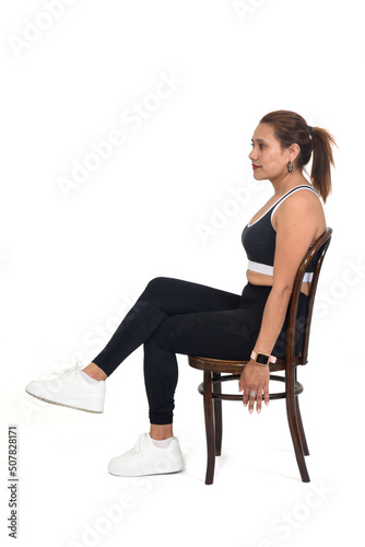 side view of women sitting on chair with sportswear legs crossed on white background
