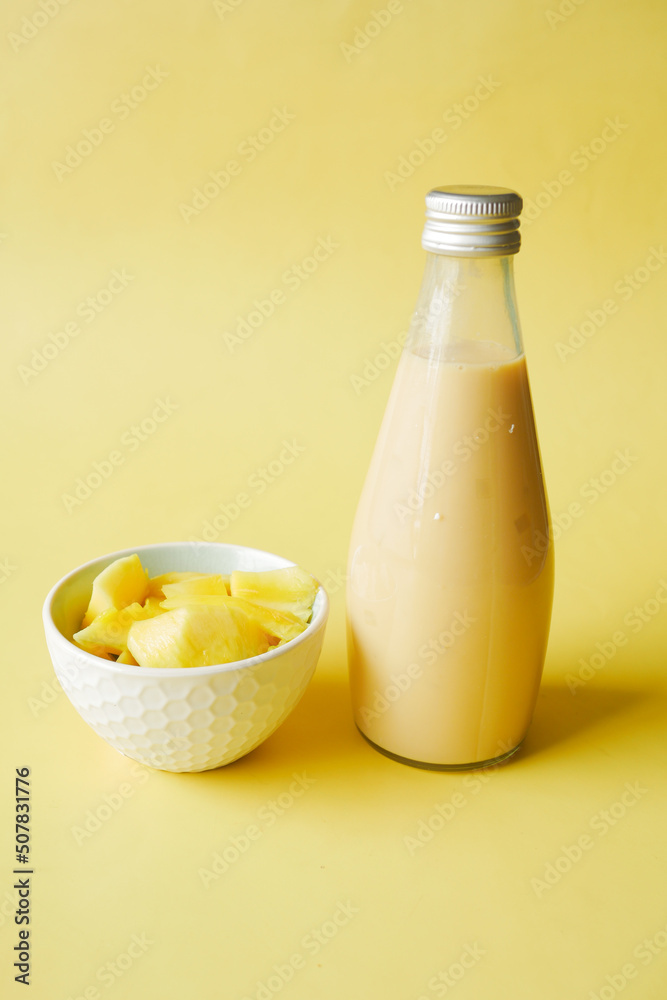 mango smoothie and fresh mango on yellow background mango smoothie and fresh mango on yellow background