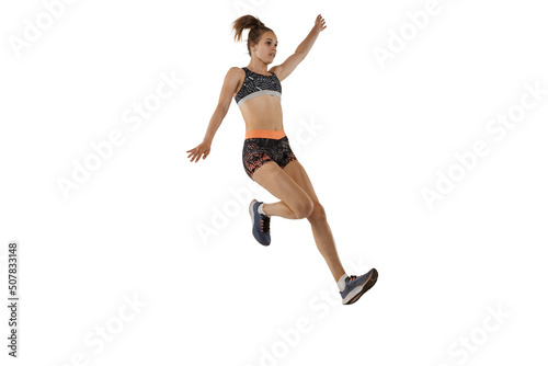 Long jump technique. Studio shot of professional female athlete in sports uniform jumping isolated on white background. Concept of sport, action, motion, speed.