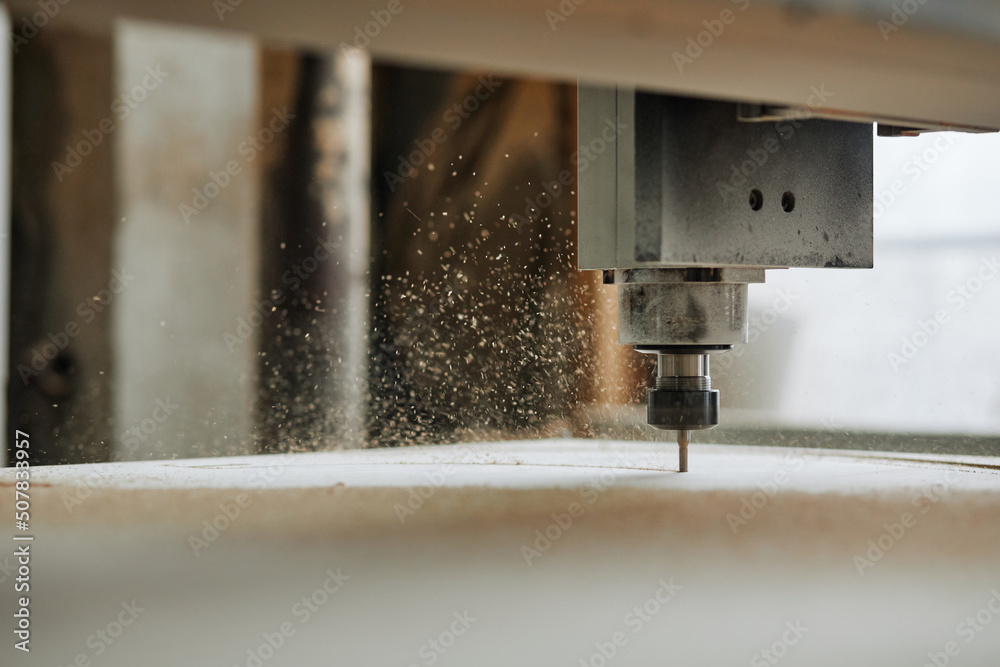 Macro shot of CNC engraving machine cutting wood in automated production workshop with sawdust flakes in air, copy space - obrazy, fototapety, plakaty 