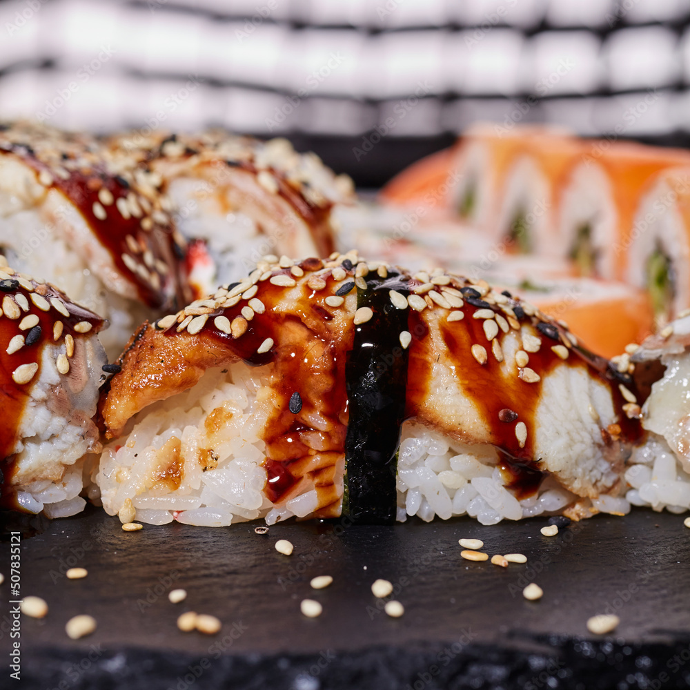 Close up of one nigiri sushi sprinkled with sesame seeds and drizzled with sauce. Close up of one nigiri sushi sprinkled with sesame seeds and drizzled with sauce.
