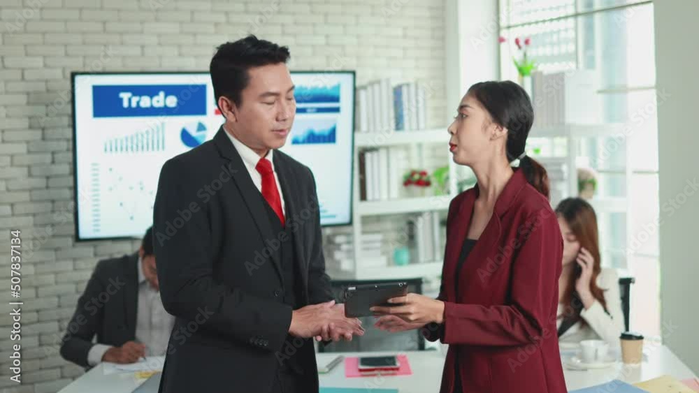 young asian female employee presenting business plan by tablet to asian male supervisor in modern office young asian female employee presenting business plan by tablet to asian male supervisor in modern office