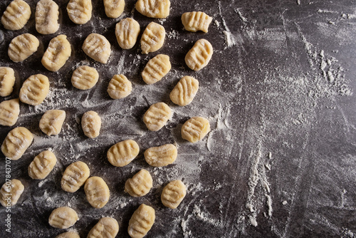 Raw traditional Italian gnocchi dish on a table with flour