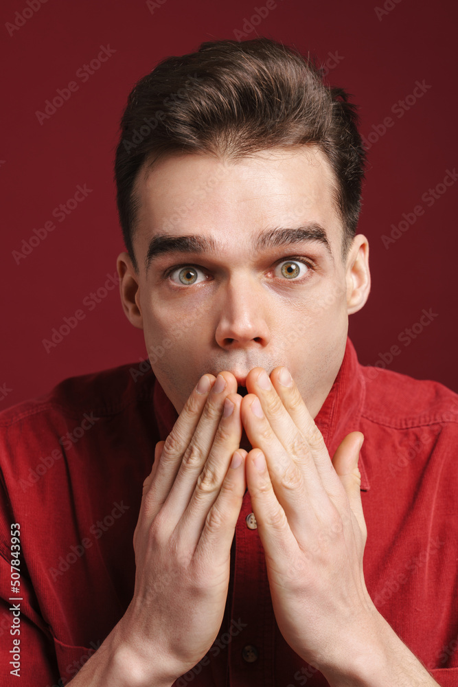 Young white man wearing shirt expressing surprise at camera Young white man wearing shirt expressing surprise at camera