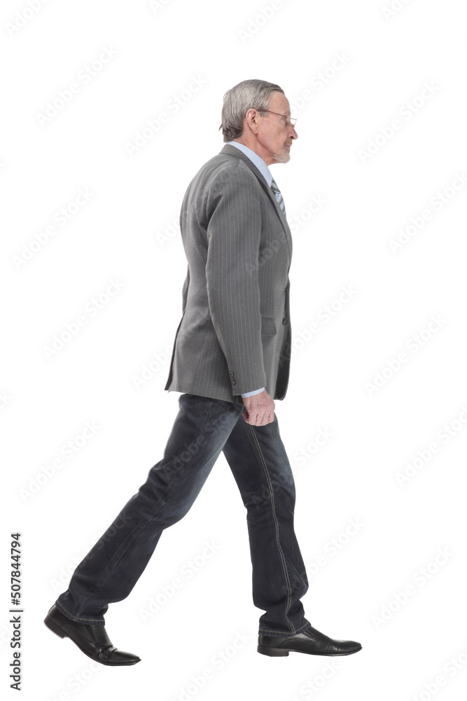 side view full length photo of a mid aged business man walking forward and looking at camera. side view full length photo of a mid aged business man walking forward and looking at camera.