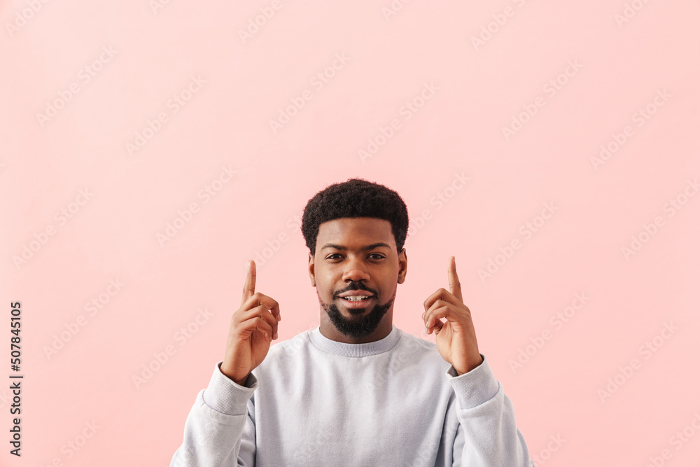Black mid man with beard smiling and pointing fingers upward Black mid man with beard smiling and pointing fingers upward