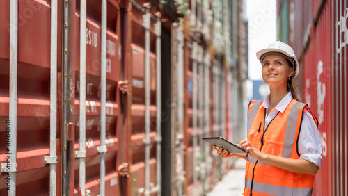 Female manager using tablet working at container yard.
